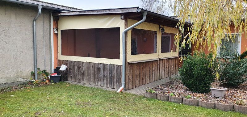 Ein Haus mit einer abgeschirmten Veranda im Hinterhof.