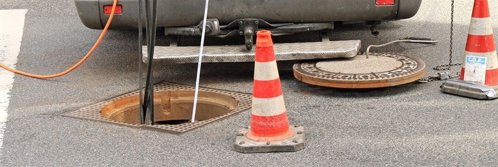 Ein Kanaldeckel wird von einem LKW geöffnet