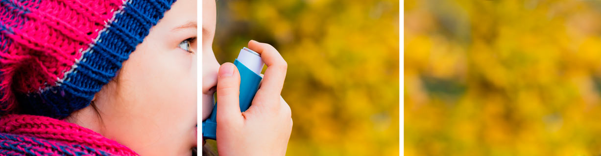 Una niña está usando un inhalador afuera.