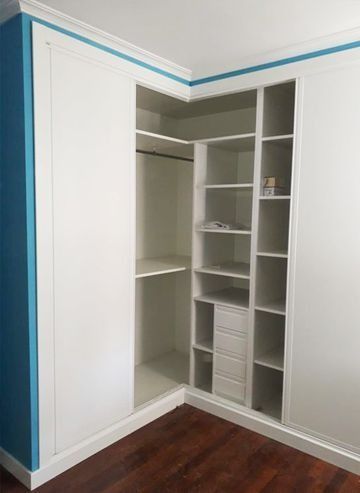 Un armario con puertas correderas y estantes en una habitación con paredes azules.