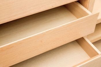 Un primer plano de un cajón de madera vacío en una cómoda.
