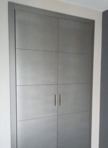 Un primer plano de un armario gris con dos puertas en una habitación.