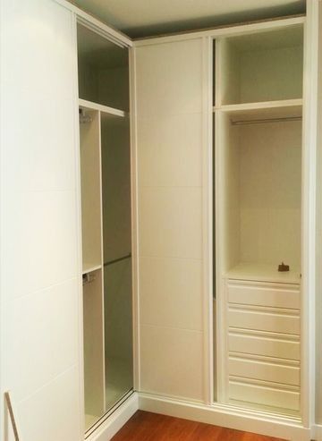 Un vestidor con puertas corredizas blancas y cajones.