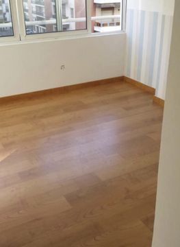 Una habitación vacía con suelo de madera y una ventana.