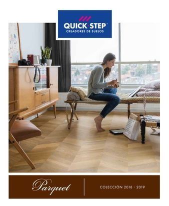 Una mujer está sentada en un banco en una sala de estar leyendo un libro.