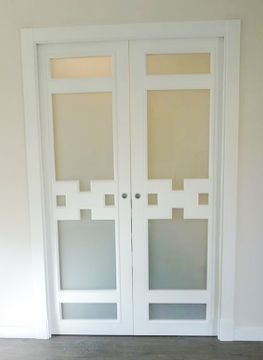 Un par de puertas corredizas blancas con vidrio esmerilado en una habitación.
