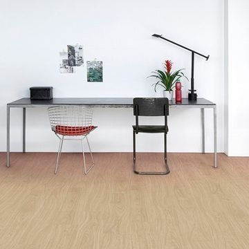 Un escritorio con una silla y una lámpara encima en una habitación.