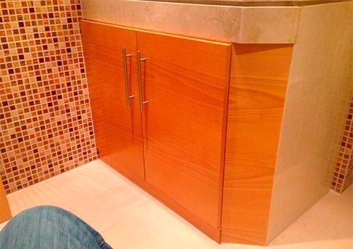 Un baño con lavabo y armarios de madera.