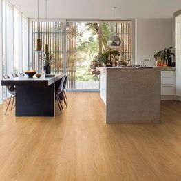 Una cocina con pisos de madera, una mesa y sillas y una gran isla.