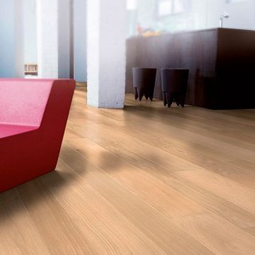 Una sala de estar con una silla roja y un piso de madera.