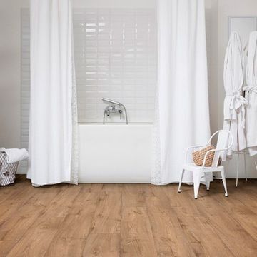 Un baño con bañera, cortina de ducha, silla y batas.