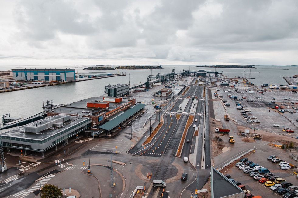 Harbor aerial view with docked ships, cargo cranes, and empty roads under a cloudy sky