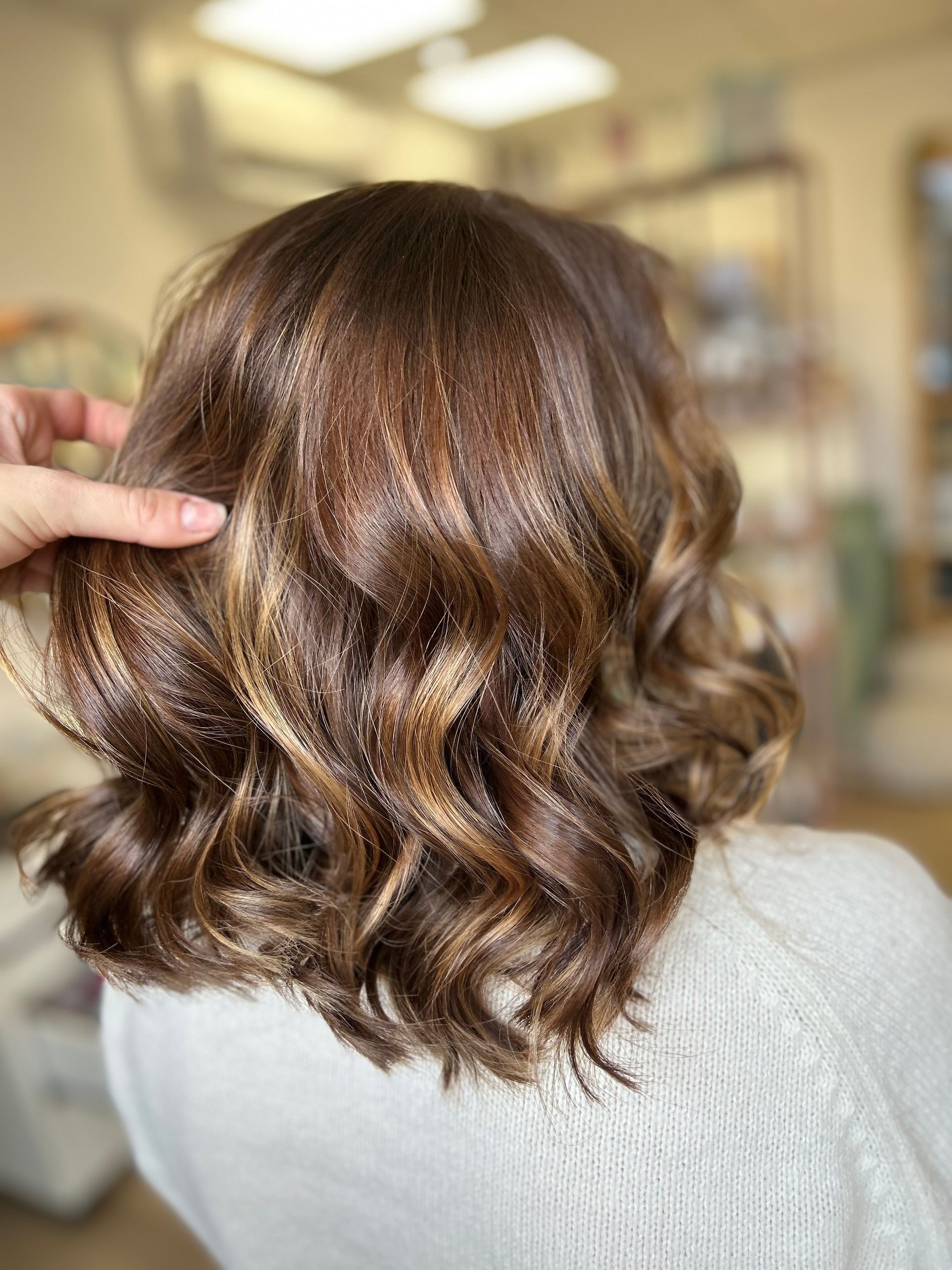 Balayage sur des cheveux coupés au carré, bruns et ondulés
