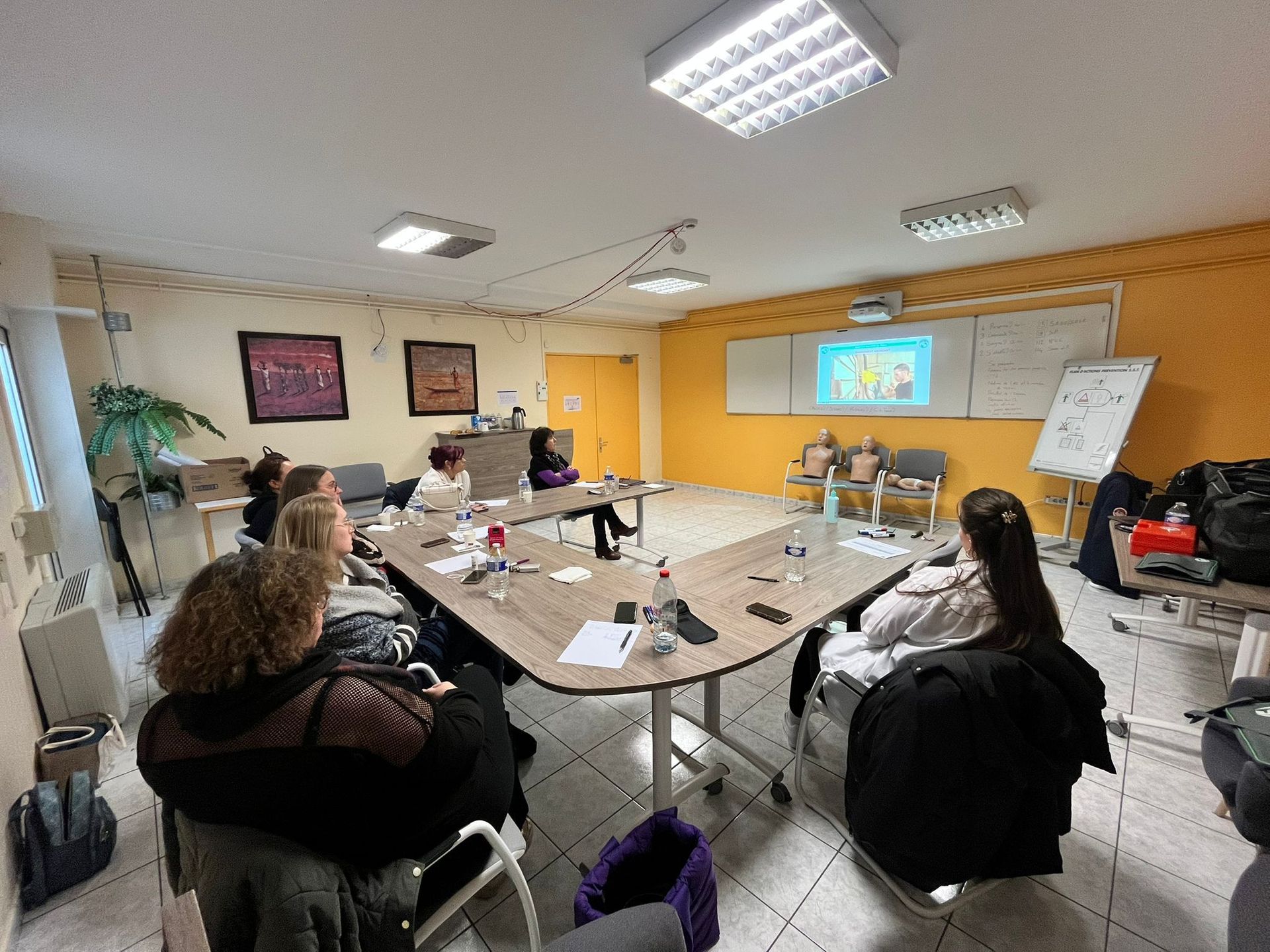 Une salle de formation avec des stagiaires assis autour d'une table.