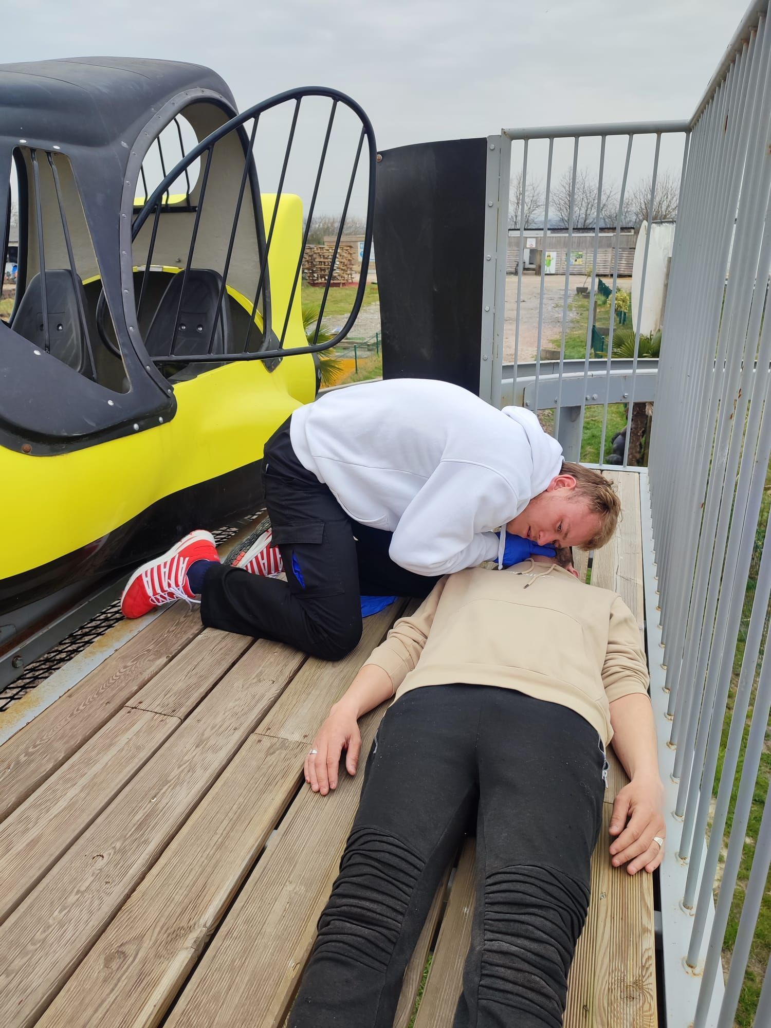 Un homme écoutant la respiration d'un homme allongé au sol.