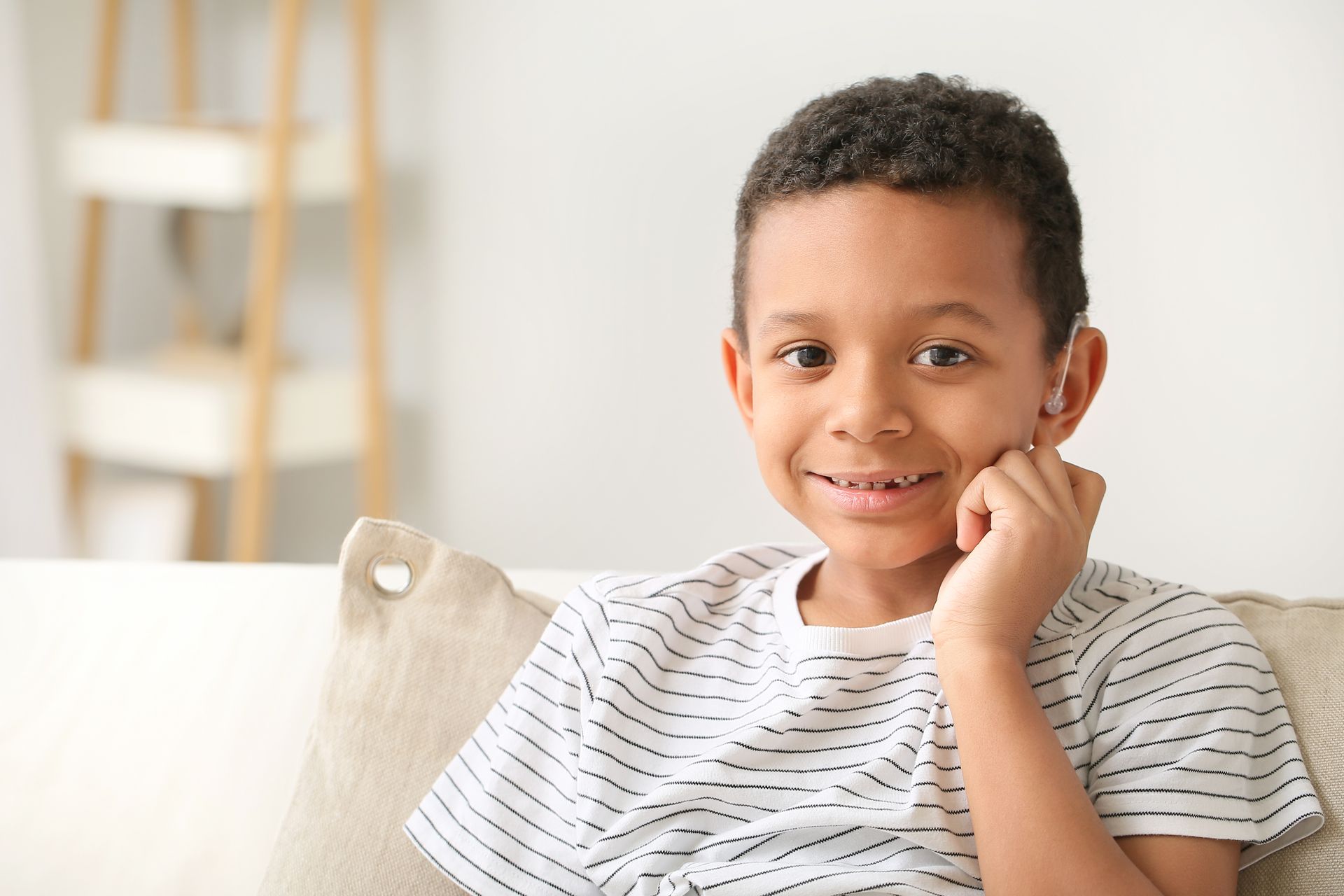 Enfant souriant avec une aide auditive