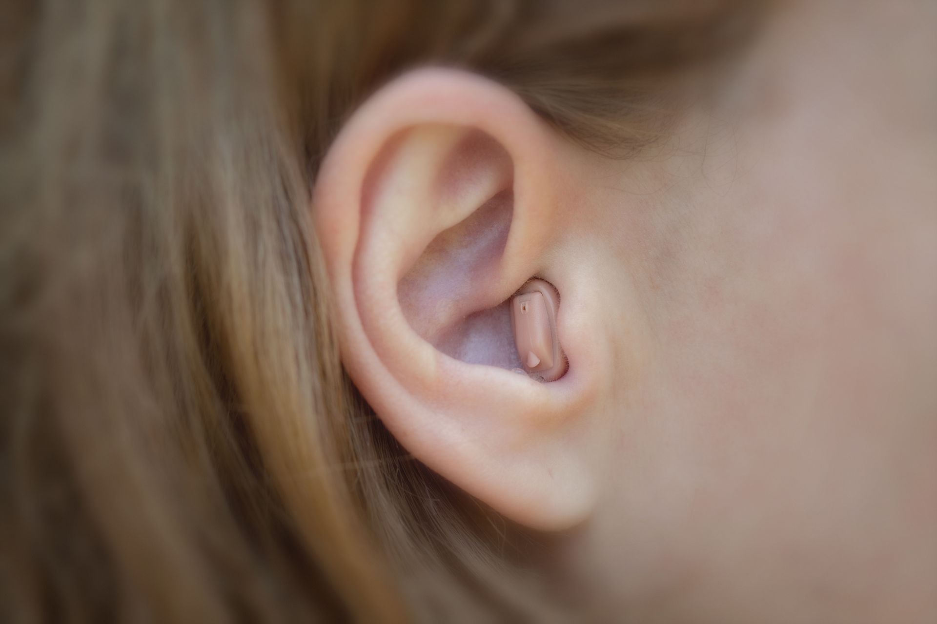 Gros plan sur l'oreille d'une femme avec un appareil intra-auriculaire