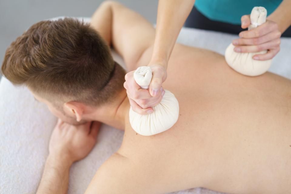 Physios - Ihre Physiotherapeuten - Mann auf Liege erhält Rückenmassage