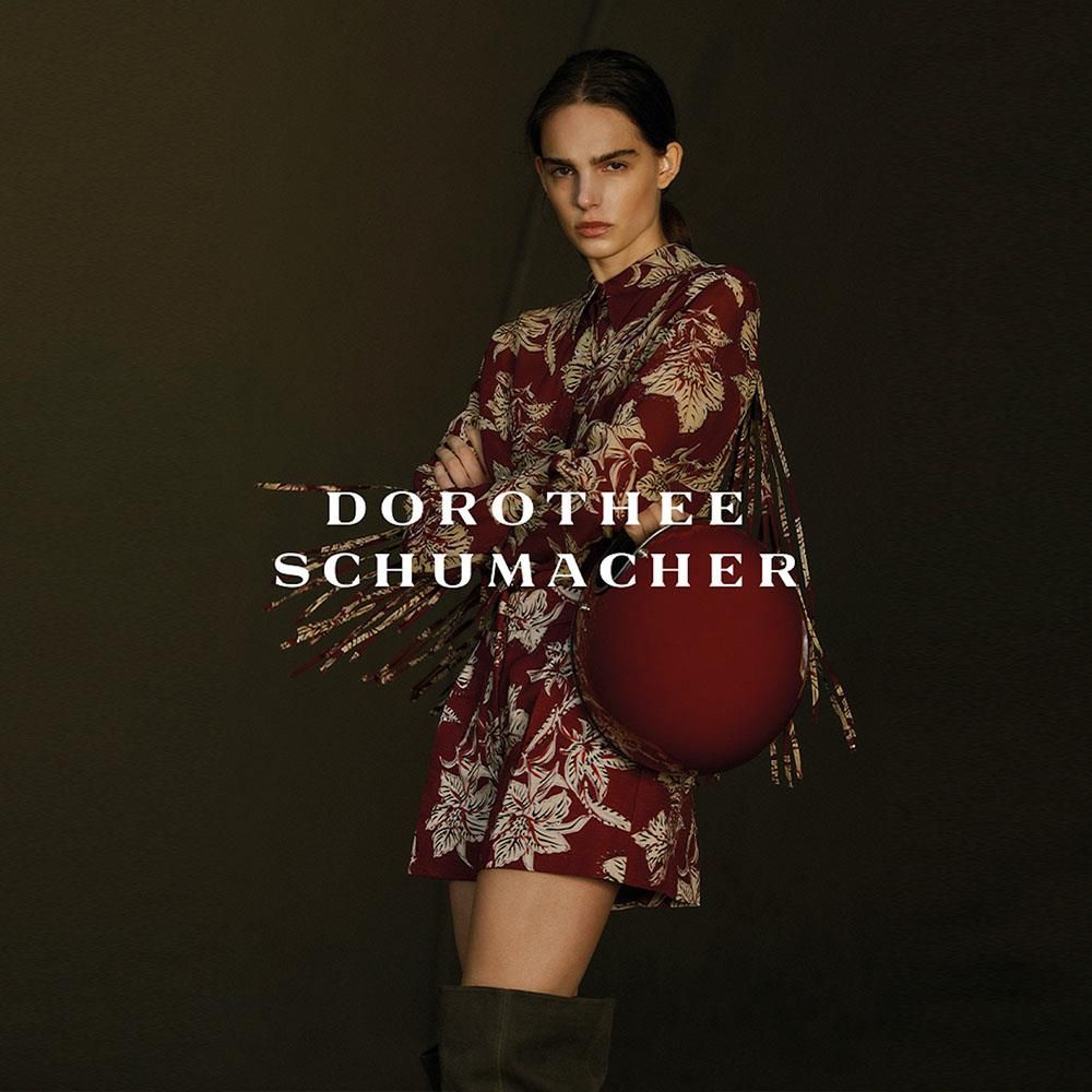 Eine Frau im roten Kleid hält eine rote Tasche von Dorothee Schumacher