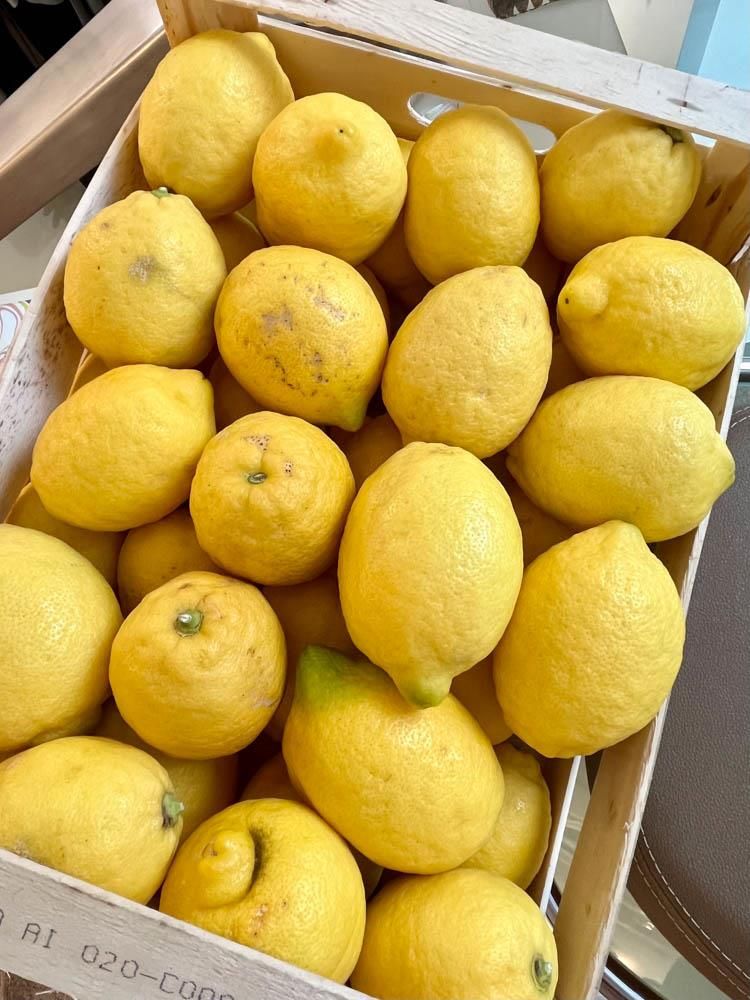 Eine Holzkiste mit vielen gelben Zitronen gefüllt