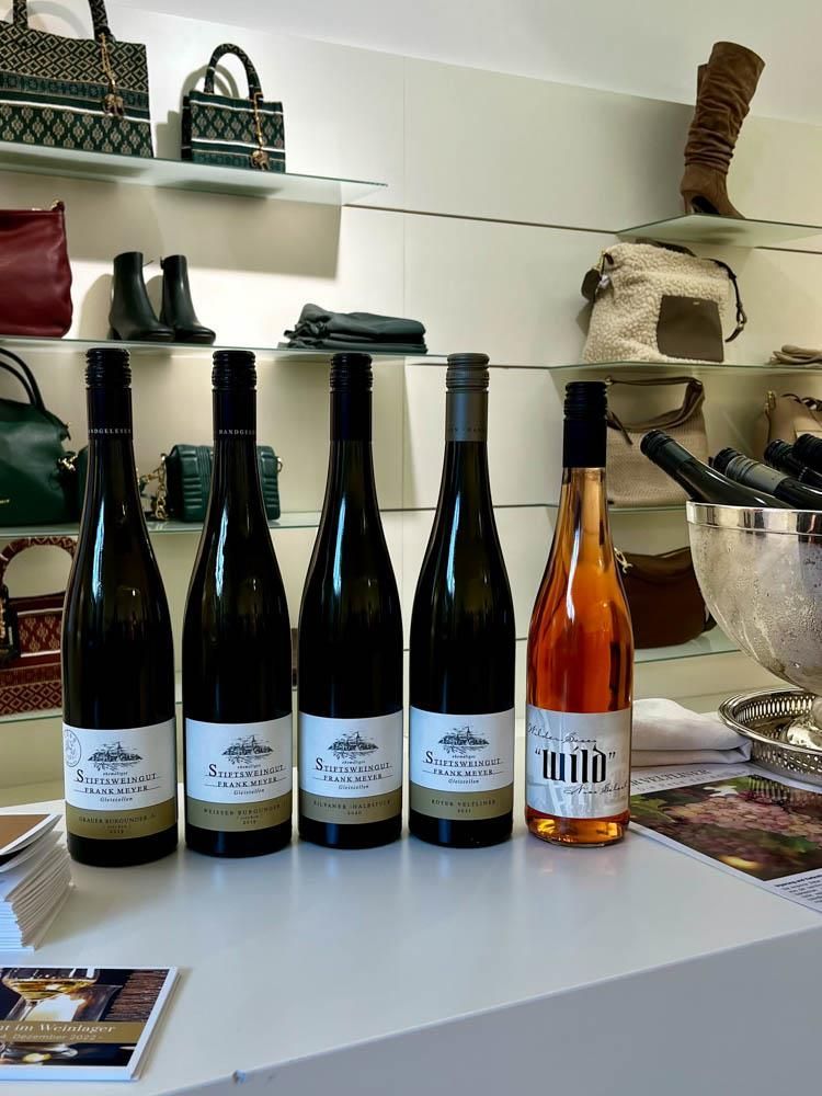 Vier Flaschen Wein stehen aufgereiht auf einem Tisch