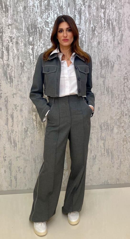 Eine Frau trägt einen Anzug und ein weißes Hemd.