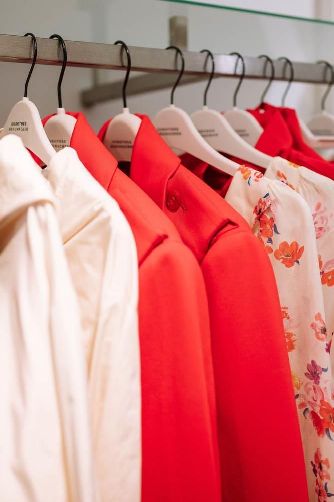 Eine Reihe roter und weißer Hemden, die an einem Ständer hängen