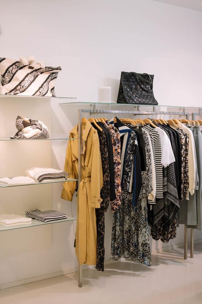 Eine Reihe von Kleidungsstücken hängt auf Ständern in einem Geschäft.