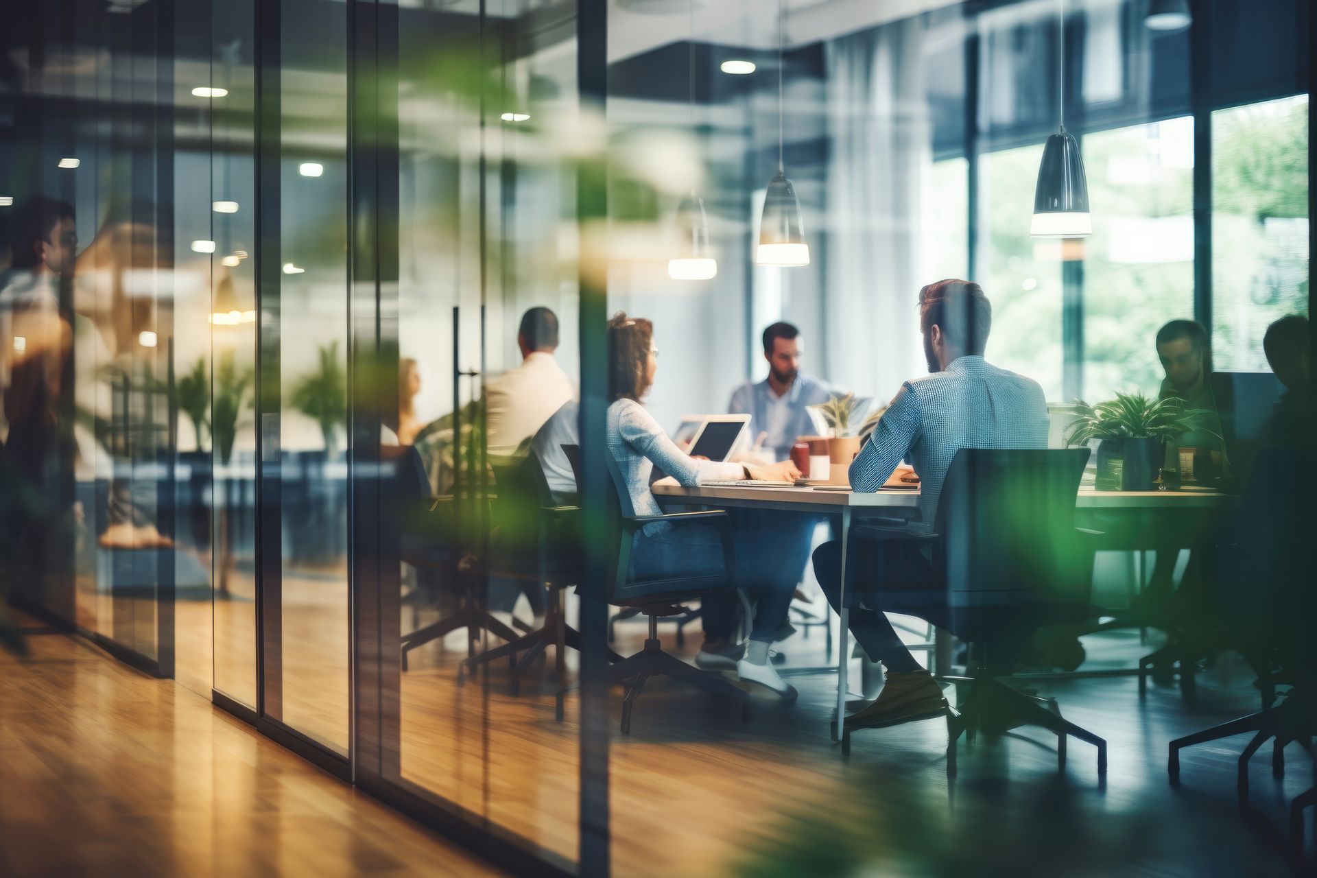 Salle de conférence vitrée avec des personnes réunies autour d'une table dans un bureau lumineux