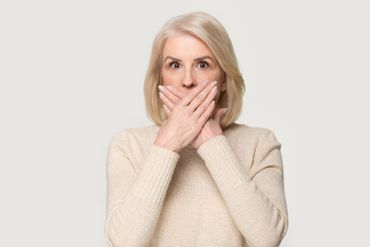 Person hält sich die Hand ans Ohr