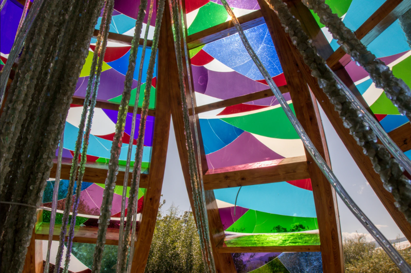 Une grande roue colorée avec un arbre en arrière-plan