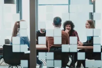 Un grupo de personas está sentada alrededor de una mesa en una sala de conferencias.