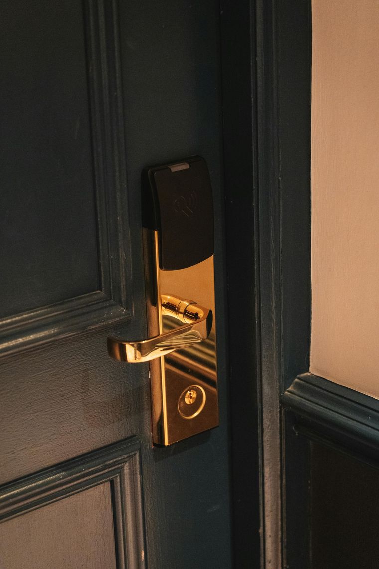 Una puerta de madera oscura de alta seguridad con manija de metal, llave insertada en la cerradura