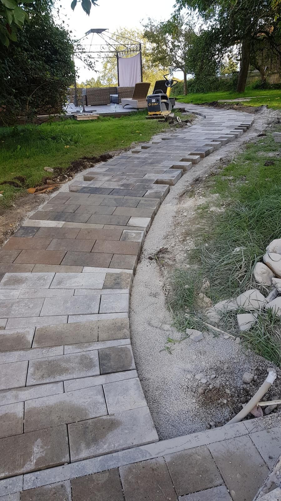 In einem Hinterhof wird ein Ziegelweg gebaut.