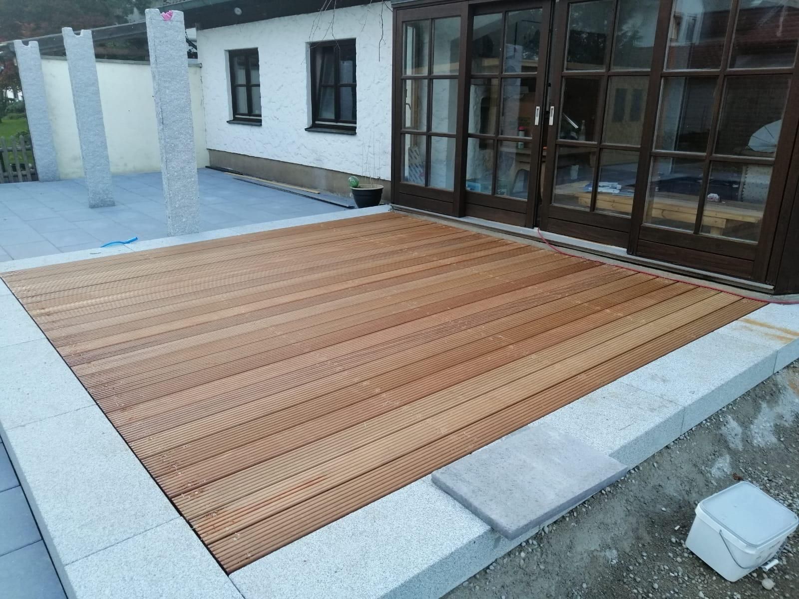 Vor einem Haus wird eine Holzterrasse gebaut