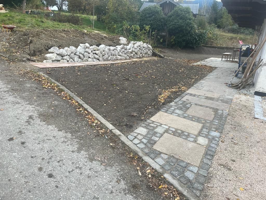 Eine unbefestigte Straße mit einem Steinweg und einem Steinhaufen am Rand.