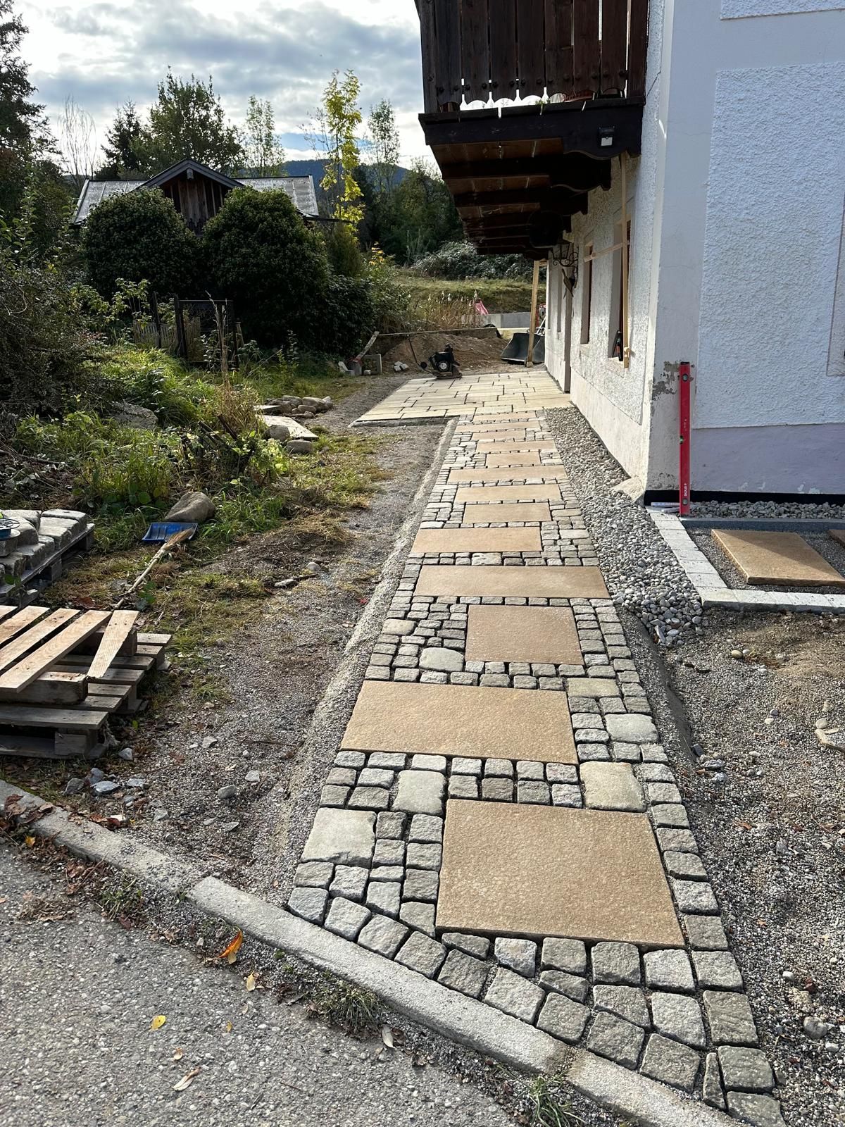 Vor einem Haus wird ein Steinweg gebaut.