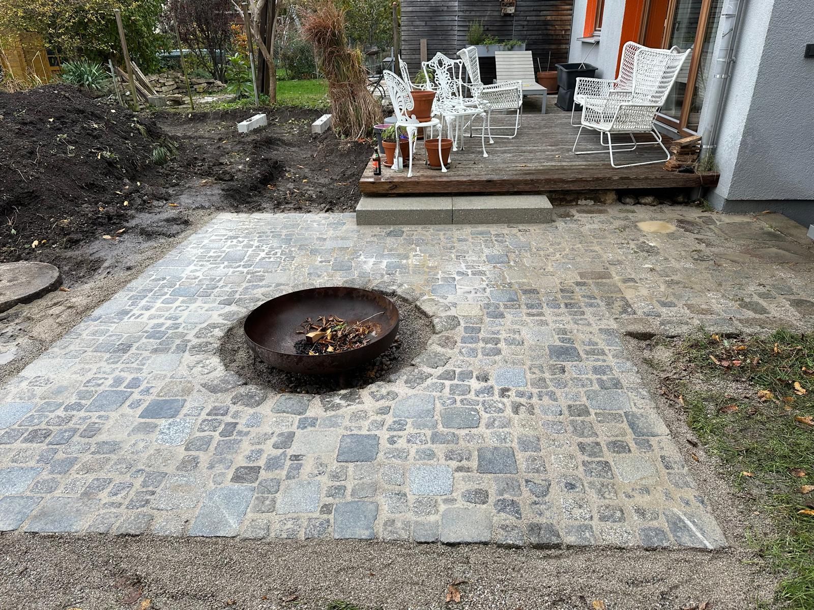 In der Mitte der Terrasse befindet sich eine Feuerstelle.