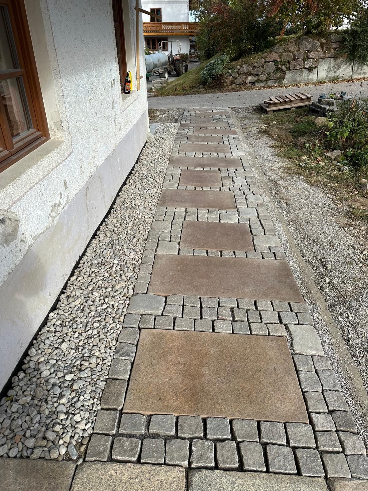Ein Steinweg führt zu einem Haus mit einem Fenster.