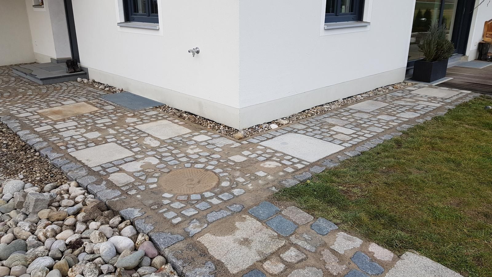 Ein weißes Haus mit einem Steinweg davor.