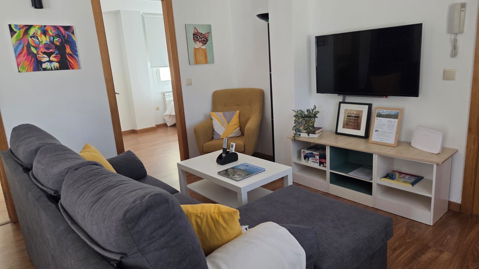 Una sala de estar con un sofá modular gris con cojines amarillos