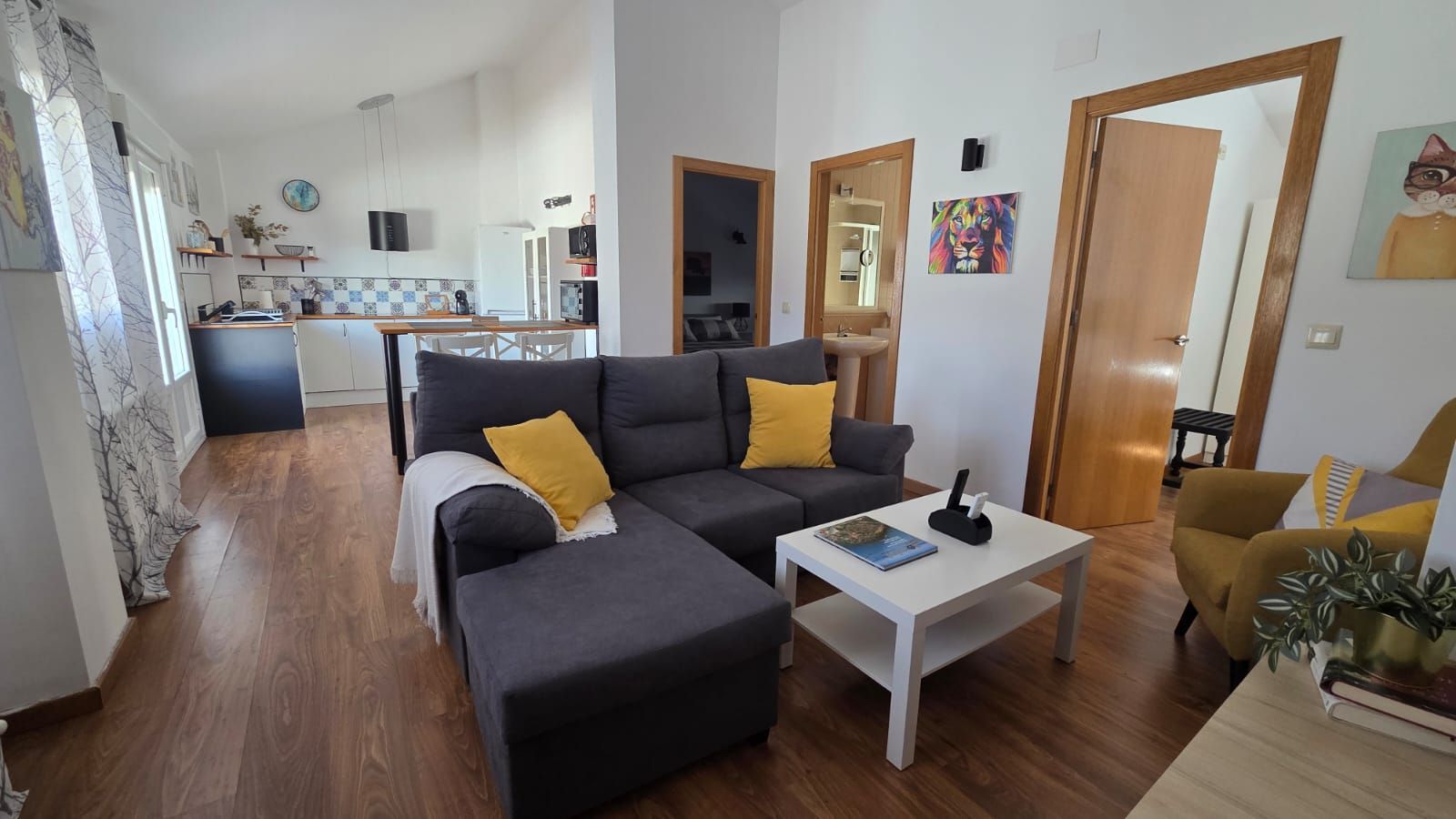 Sala de estar con un sofá modular gris oscuro, cojines decorativos amarillos