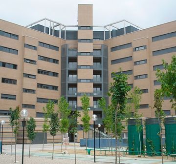 Un gran edificio con muchas ventanas y árboles en el frente.