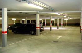 Un estacionamiento con coches estacionados en él y columnas.
