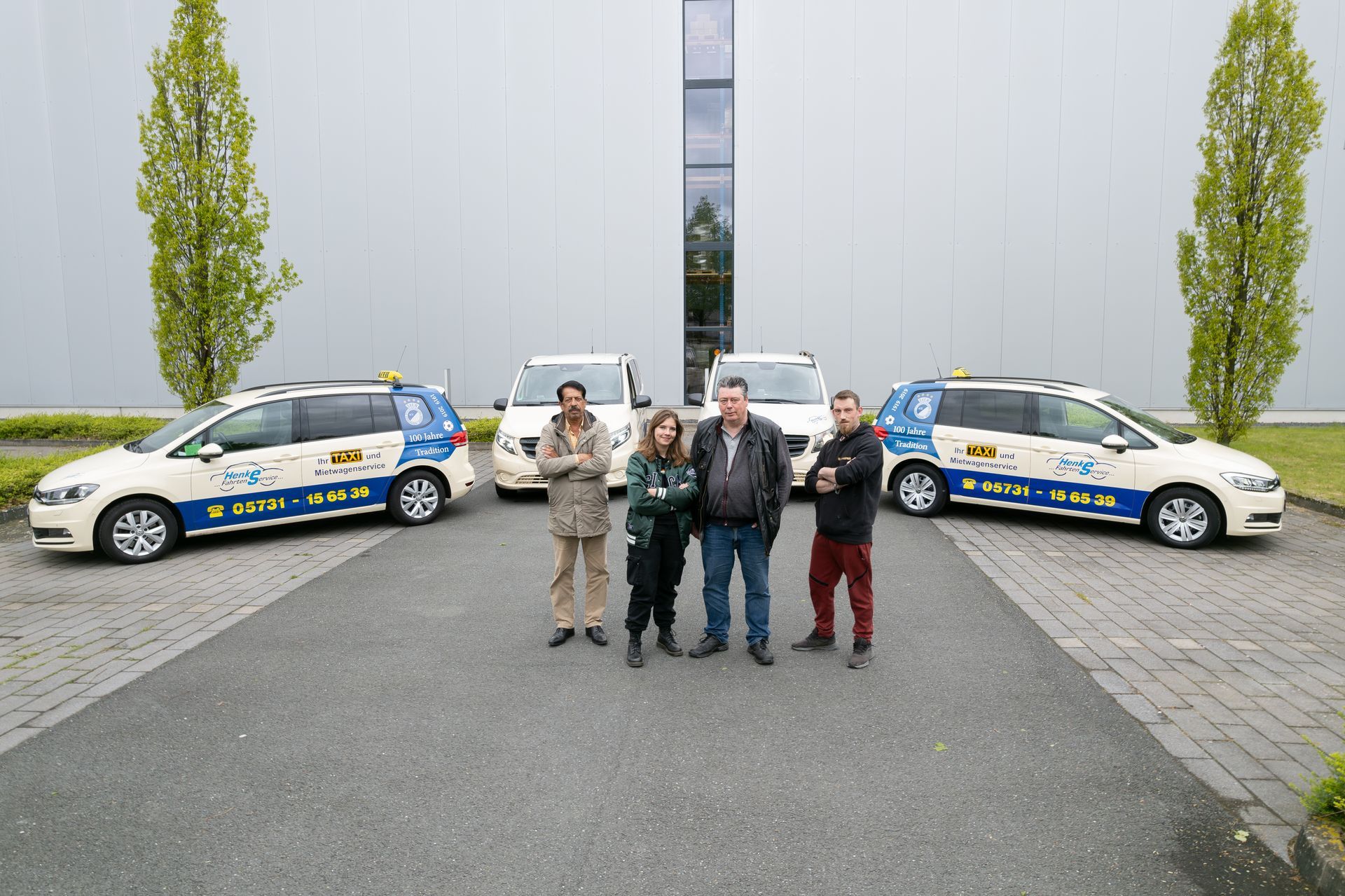 Eine Gruppe von Menschen posiert vor einem Gebäude für ein Foto.
