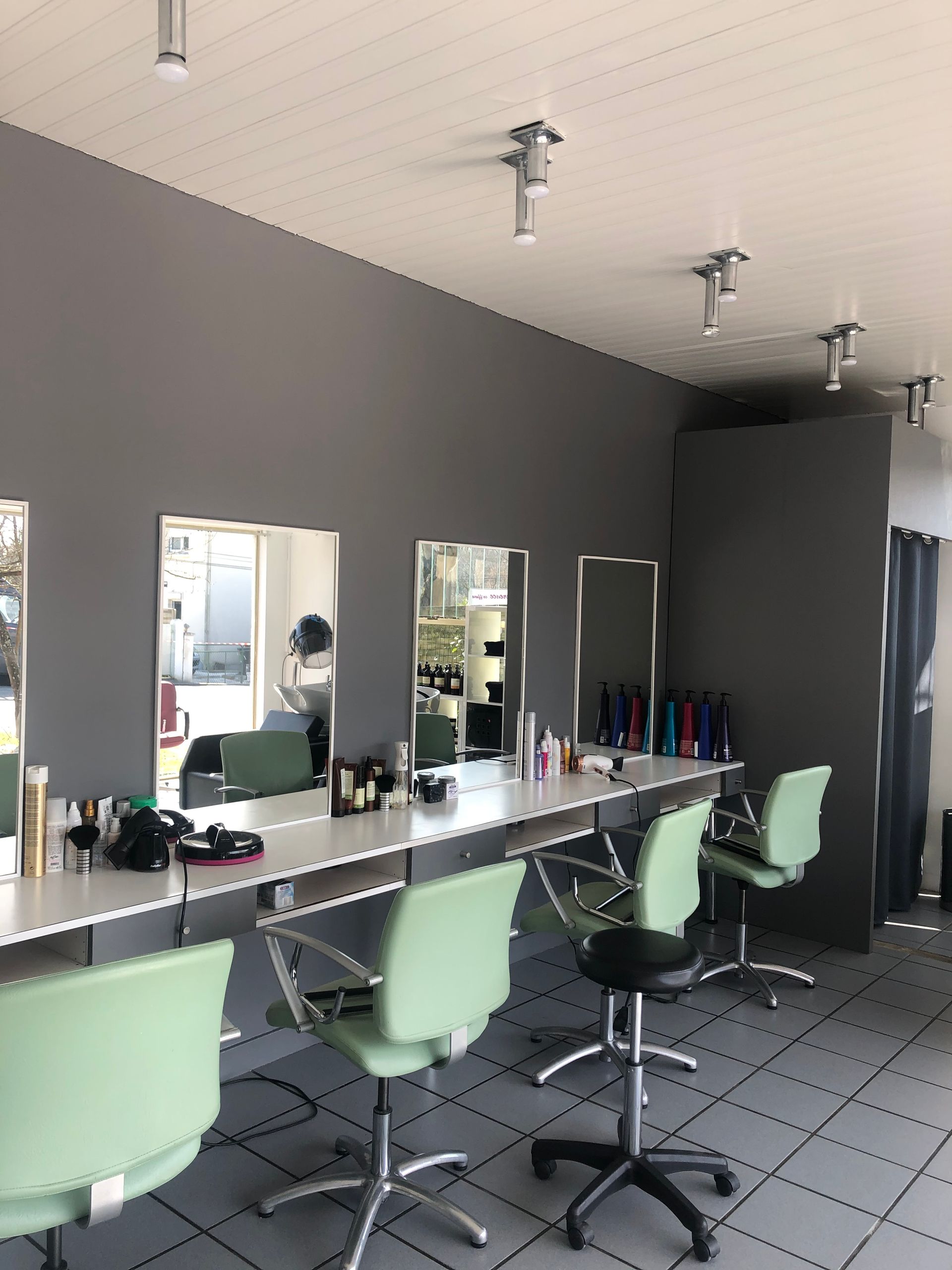 Intérieur du salon, quatre fauteuils vert d'eau face aux miroirs