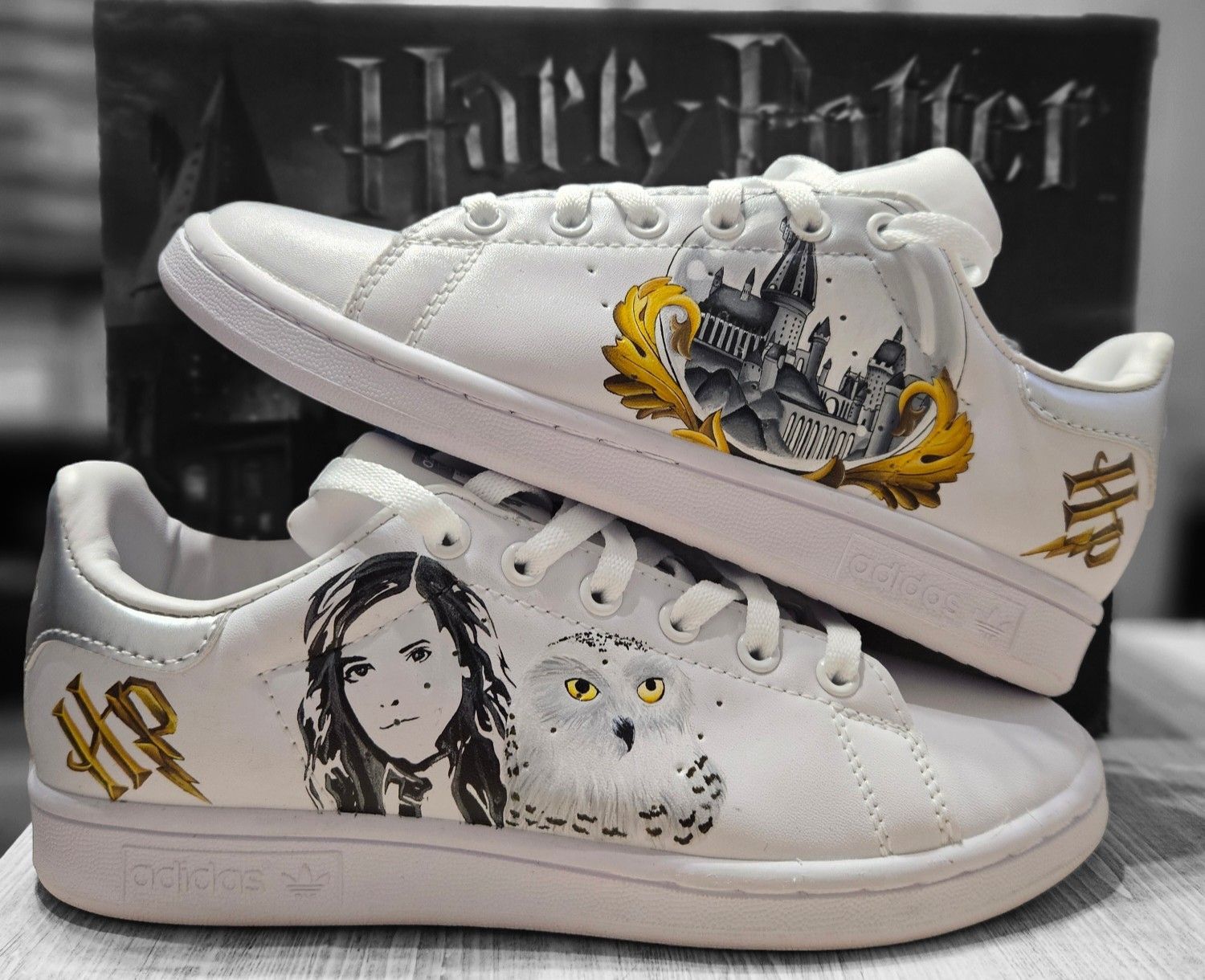 Chaussure blanche Adidas pour tout-petit avec des accents roses, un design de personnage et des sangles velcro.