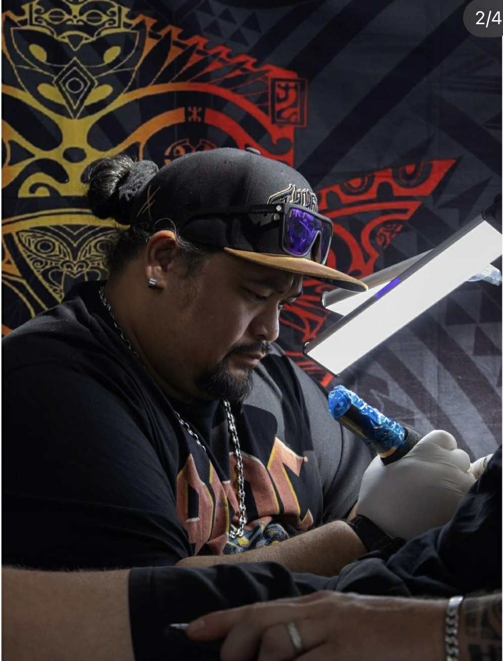 Bras tatoué dans un style polynésien traditionnel, avec des motifs géométriques noirs complexes sur l'épaule et l'avant-bras.