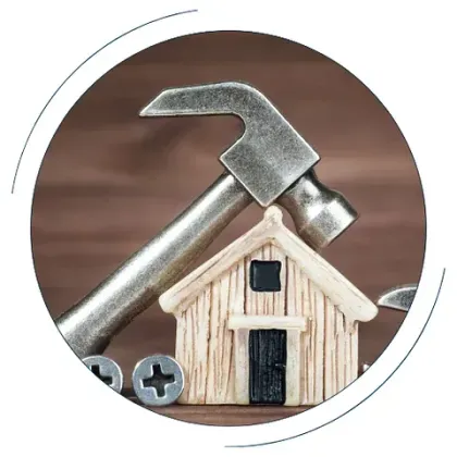 Se está construyendo una casa de madera con un martillo y tornillos.