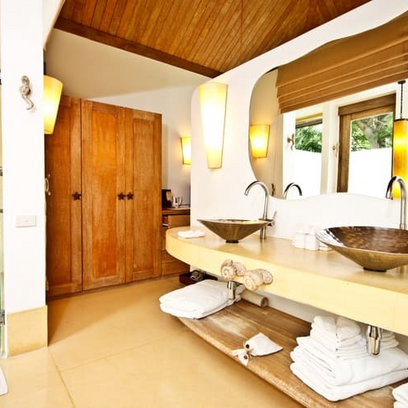 Un baño con dos lavabos y un espejo grande.